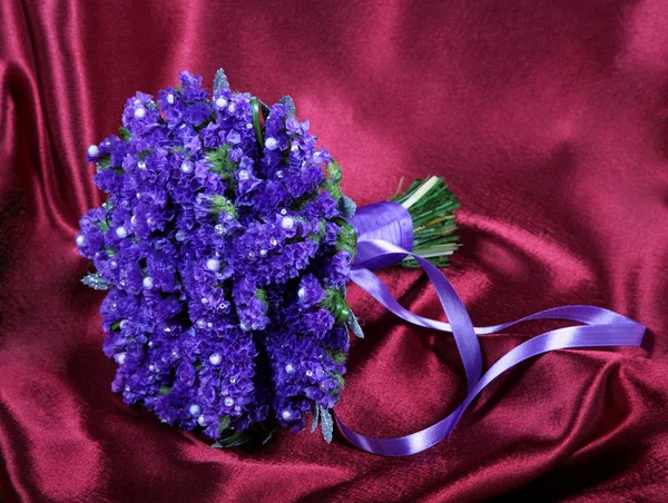 Buquê de casamento de violetas em um tecido vermelho — Fotografia de Stock