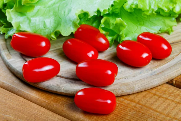 Tomates pequenos e folhas de salada fecham — Fotografia de Stock