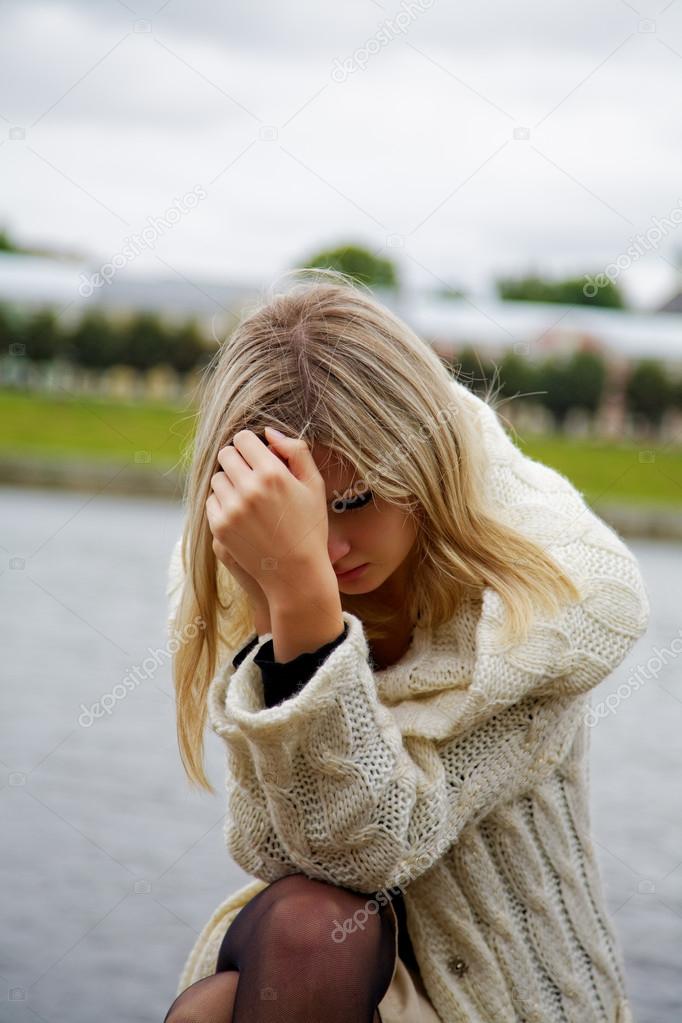 The girl in despair and grief against the river