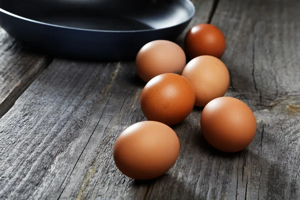 Натюрморт з яйцями і сковородою на дошках — стокове фото