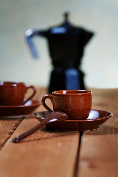 Cups of coffee and a coffee pot on a rural table — Stock Photo, Image