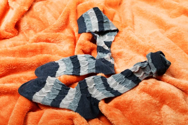 Female socks on an orange blanket — Stock Photo, Image