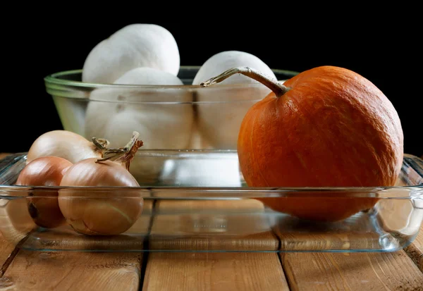 Kleiner Kürbis und Zwiebeln in einem Glasteller — Stockfoto