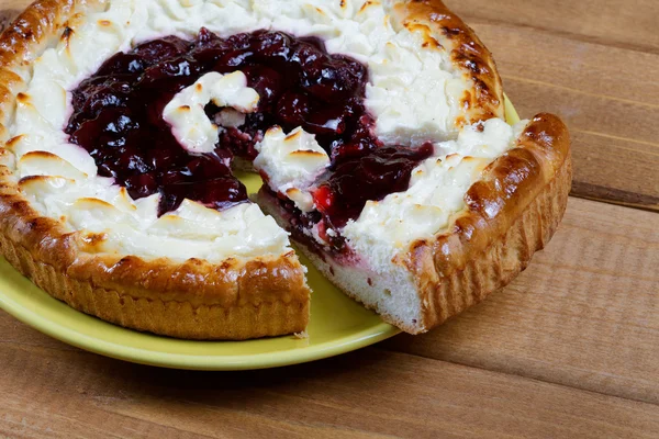 Couper le gâteau avec de la confiture sur une table rustique — Photo