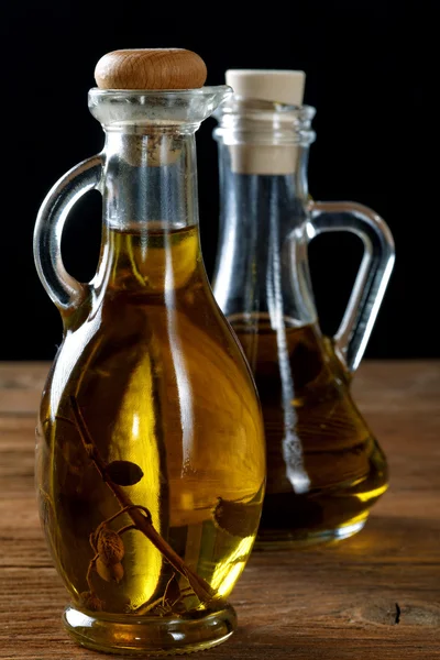 Duas garrafas de azeite na mesa rústica — Fotografia de Stock
