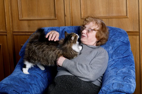 La abuela con el gato en las condiciones de casa — Foto de Stock