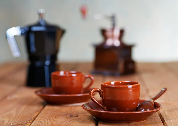 Cups of coffee and a coffee pot on a rural table — Stock Photo, Image