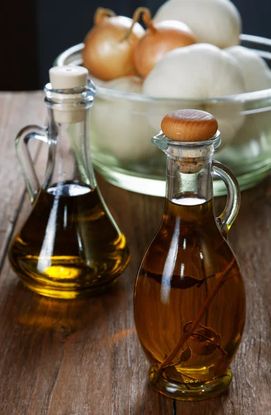 Dos botellas de aceite de oliva sobre mesa rústica — Foto de Stock
