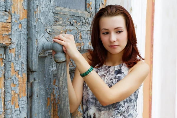 Žena otevírá staré dveře — Stock fotografie