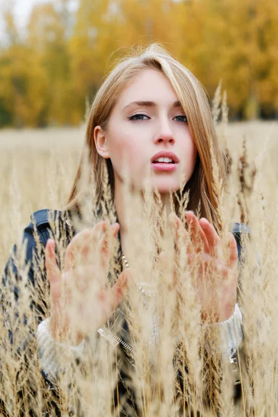 The girl in a leather jacket among a yellow grass — Stock Photo, Image