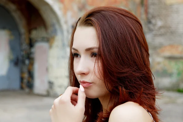 Portrait of a pensive girl on a background of old wall — Stock Photo, Image