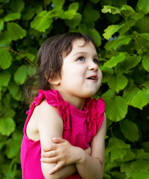 Niña haciendo muecas sobre un fondo de follaje — Foto de Stock