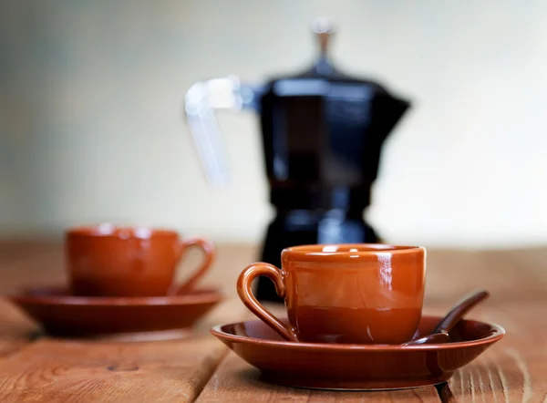 Cups of coffee and a coffee pot on a rural table — Stock Photo, Image