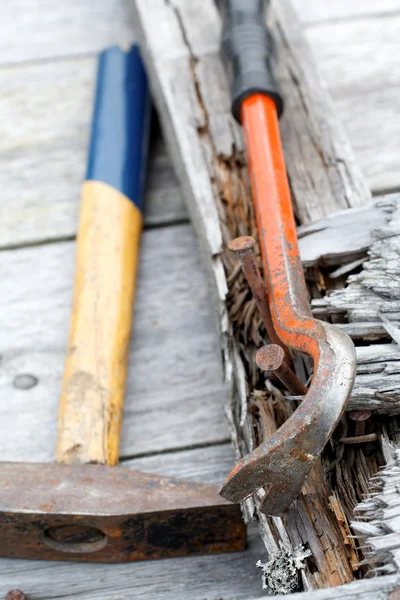 Krallenhammer und rostige Nägel auf den alten Brettern — Stockfoto