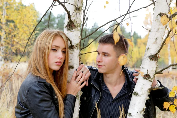 Boy and girl at a birch in autumn — Stock Photo, Image