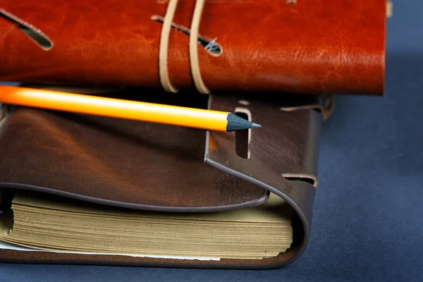 Pile of notebooks in leather covers and a pencil close up — Stock Photo, Image