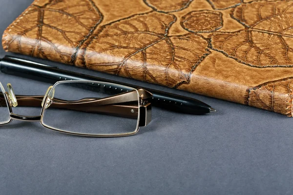 Pencil glasses and a writing-book close up — Stock Photo, Image