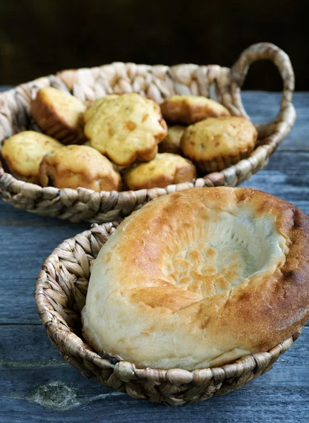 Rolls in a wattled basket on an old kitchen table — Stock Photo, Image