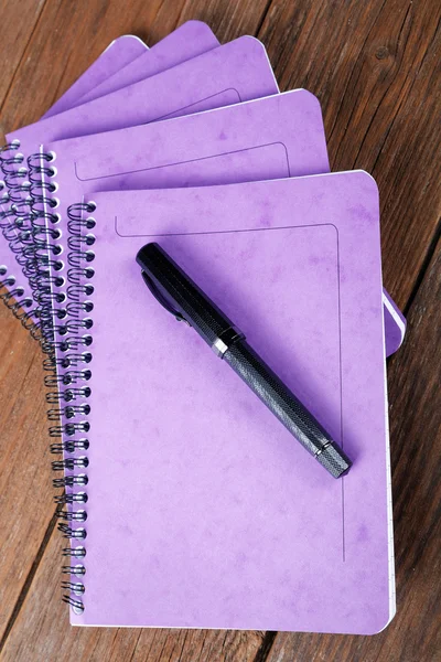 Pilha de cadernos e caneta-tinteiro na mesa — Fotografia de Stock