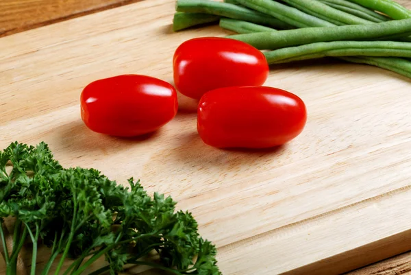 Small tomatoes and salad leaves close up — Stock Photo, Image