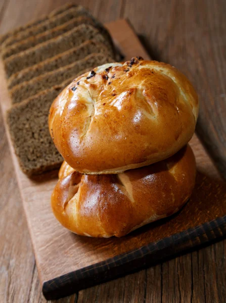 Buns with mushrooms and black bread on rustic table — Stock Photo, Image