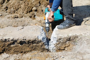 Worker hammer smashes the concrete foundation clipart