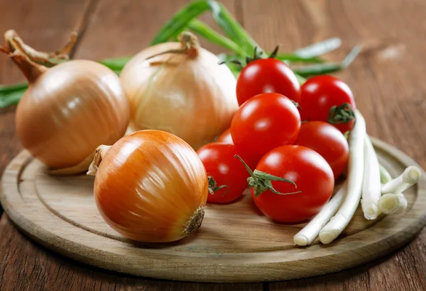 Tomates napiformes de cebolla sobre una vieja mesa rural — Foto de Stock