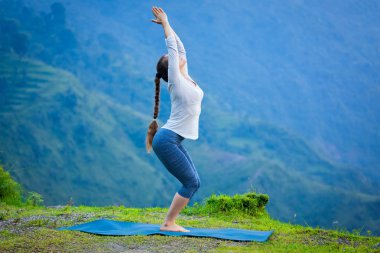 Kadının Yoga asana Utkatasana açık havada yapması