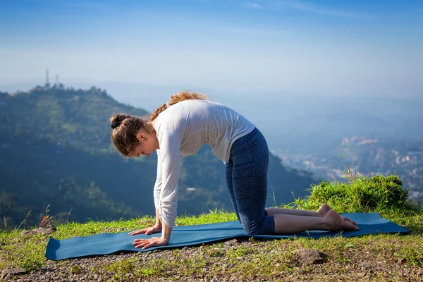 Mujer practica yoga asana Marjariasana al aire libre — Foto de Stock