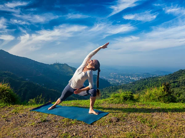 Vrouw oefent yoga asana Utthita Parsvakonasana buiten — Stockfoto