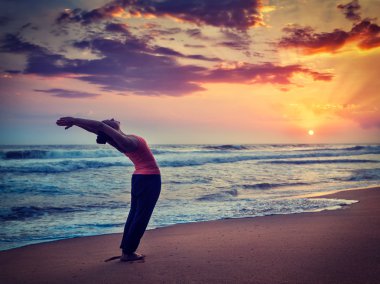 Sportif genç kadının yoga Sun salutation Surya Namaskar yapması yerleştirmek