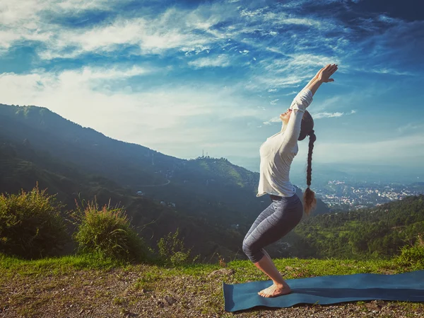 Vrouw doet yoga asana Utkatasana buiten — Stockfoto