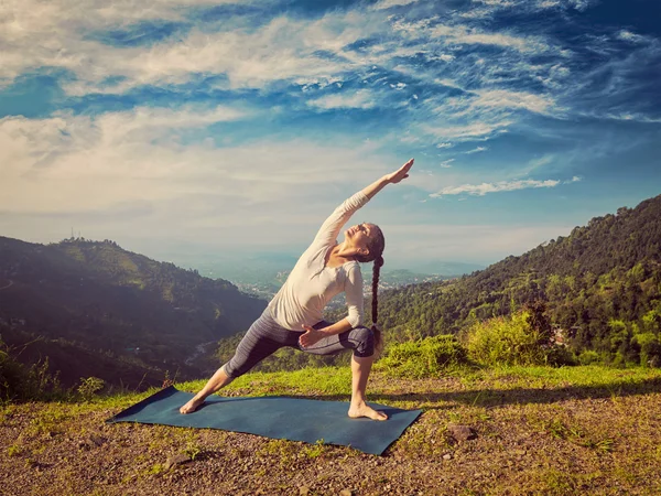 Žena cvičí jógu asana Utthita Parsvakonasana venku — Stock fotografie