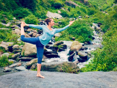 Şelalenin orada yoga yapan kadın Natarajasana.