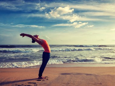 Sportif genç kadının yoga Sun salutation Surya Namaskar yapması yerleştirmek