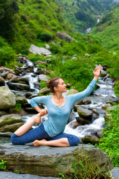 Sorty fitte Frau beim Yoga-Asana im Freien am tropischen Wasserfall — Stockfoto