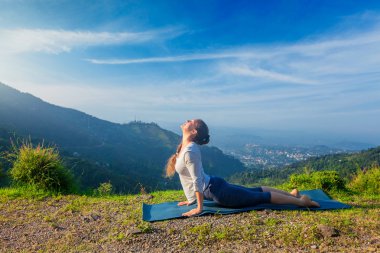Kadın yoga yapıyor, Urdhva Mukha Svanasana açık havada.