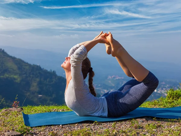 Ashtanga VinyasaヨガアサナDhanurasanaを行う女性- bow pose — ストック写真