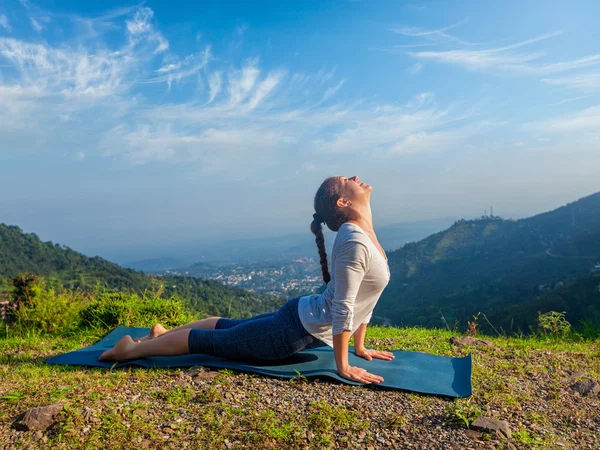 Mujer practica yoga asana Urdhva Mukha Svanasana al aire libre — Foto de Stock