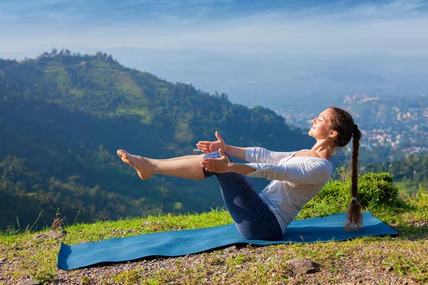 Kobieta robi Ashtanga Vinyasa Yoga asana Navasana - pozycja łodzi — Zdjęcie stockowe