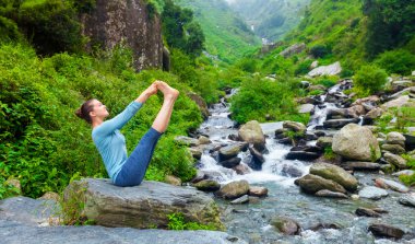 Kadın dışarıda Ashtanga Vinyasa Yoga yapıyor.