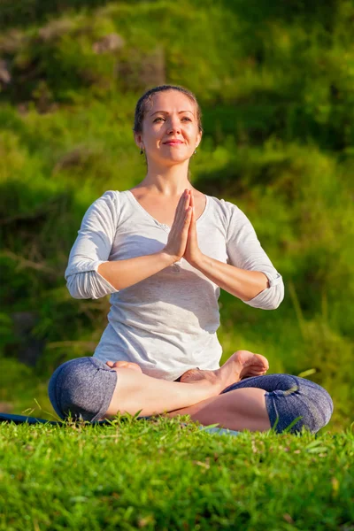 Ung sportig passform kvinna gör yoga Lotus pose utomhus — Stockfoto