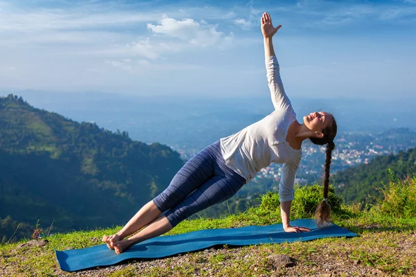 Vrouw doet yoga asana Vasisthasana - zijplank poseren buiten — Stockfoto