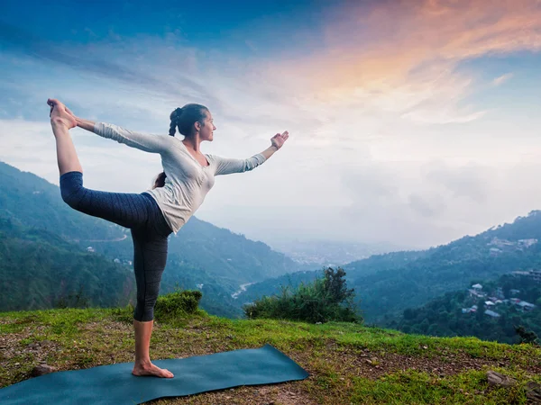 Vrouw doet yoga asana natarajasana buiten bij waterval — Stockfoto