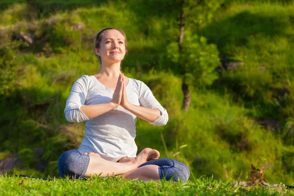 Young sporty fit woman doing yoga Lotus pose oudoors — Stock Photo, Image