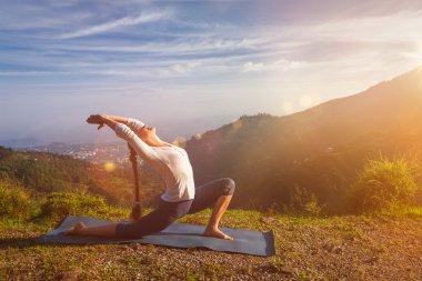 Sportif fit kadın dağlarda yoga yapıyor.