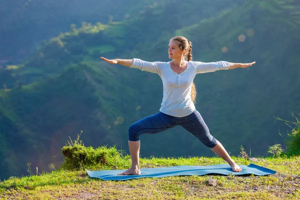 Женщина, занимающаяся йогой asana Virabhadrasana 2 - Воин позировать на открытом воздухе — стоковое фото