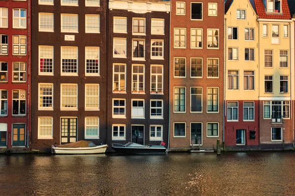 Дома и лодки на амстердамском канале Дамрак на закате — стоковое фото