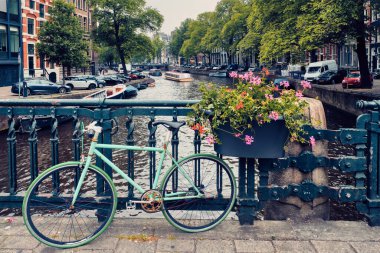 Amsterdam Kanalı 'nda bir köprü üzerinde tekneler ve bisikletlerle