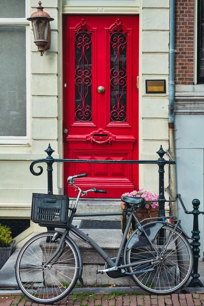 Amsterdam caddesinde eski evin kapısının yanında bisiklet. — Stok fotoğraf